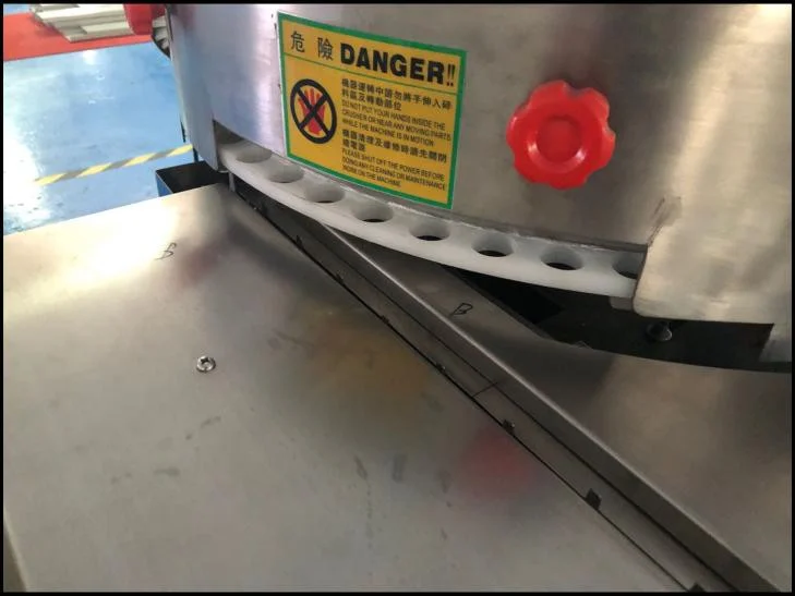 SW-1200 candy tray mold outlet — individual candy drops from sorting tray mold cavity onto infeed conveyor