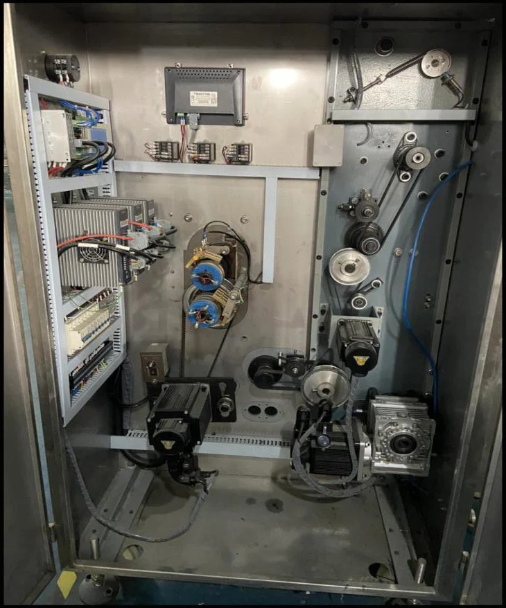 SW-1200 electrical cabinet interior — three servo motors with drive units for film pull, film feed, and rotary cutter