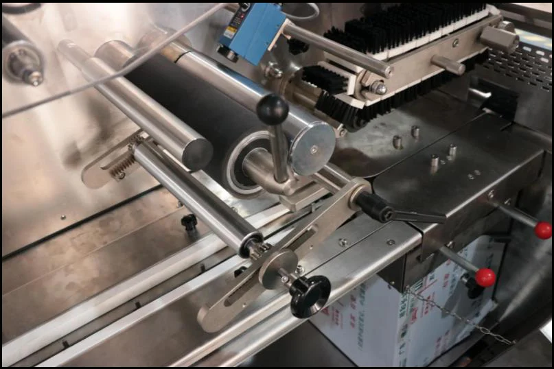 SW-300B film tensioning rollers and forming section where rollstock film is guided and shaped around products