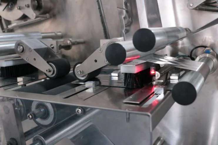 SW-300B sealing and cutting zone showing fiber sensor with red detection light for empty-bag detection