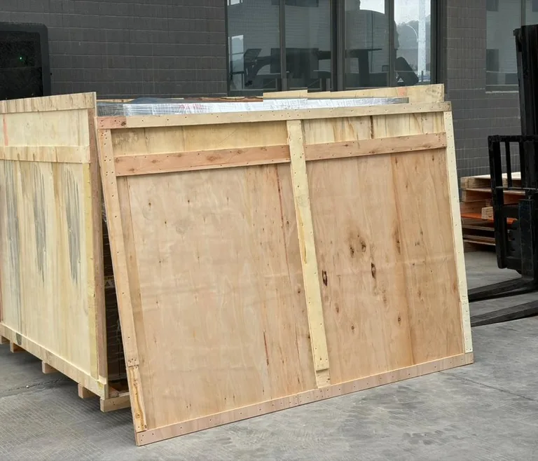 Wooden export crate with plastic wrapping and a forklift at the factory loading=
