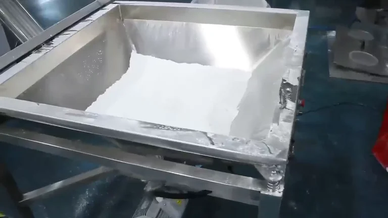 Stainless steel feed hopper filled with white powder