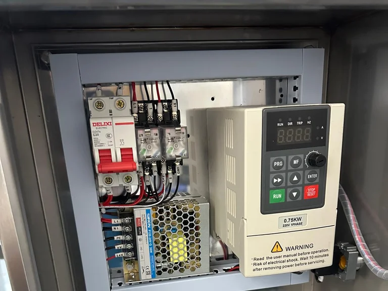 Open electrical box with a two-pole breaker, relays, a 24 V power supply and a 0.75 kW frequency inverter